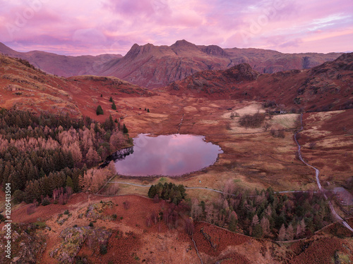 Beautiful aerial drone landscape image of Blea Tarn and Langdale Valley in Lake District during vibrant Autumn sunrise photo