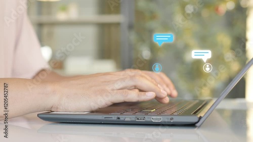 Close-up of hands typing on a laptop keyboard with digital chat bubble icons hovering above, symbolizing online communication and messaging.