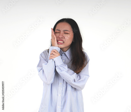 Asian women with light blue shirt and long hair having a tooth ache pain. Indonesian girl with hands touching the cheek isolated on horizontal white background. photo