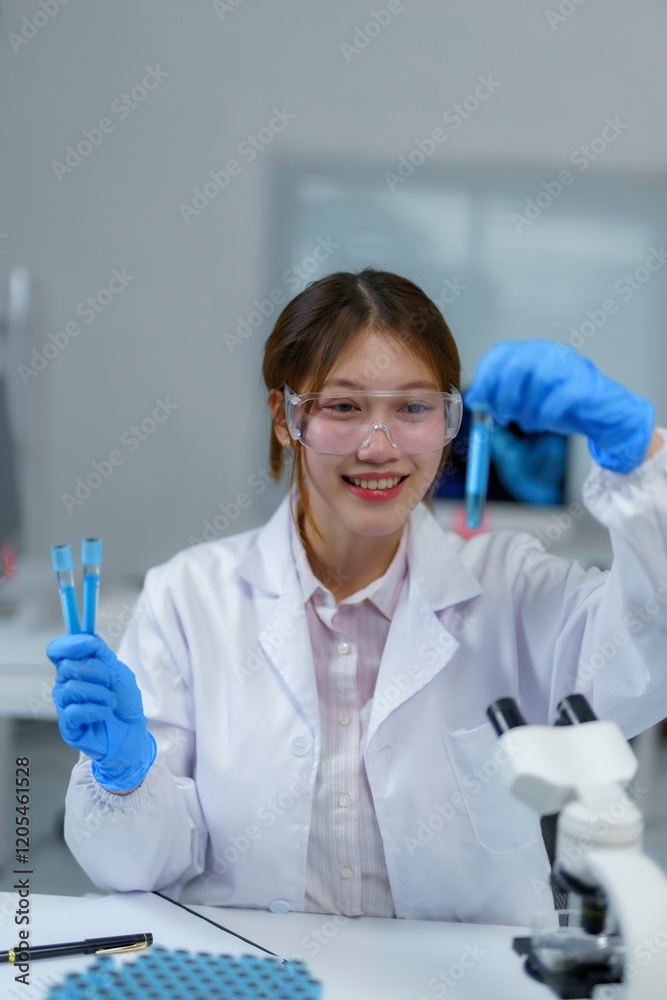 Fototapeta premium Young scientist comparing liquid in test tubes while smiling in laboratory