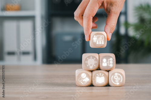 Wooden blocks with icons symbolize capacity building, showcasing growth, development, and skill enhancement in a professional setting. photo