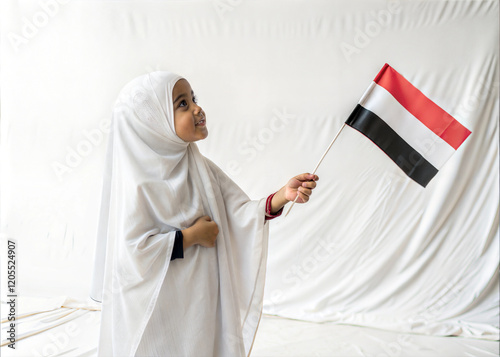 A young Girl wears a white Hijab with the Yemeni Flag photo