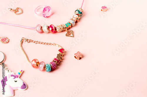Charm Bracelets with Vibrant Beads on Soft Pink Background.Decorative Beaded Jewelry with Heart and Unicorn Charms.Pastel Pink Charm Jewelry Scene for Custom Designs.