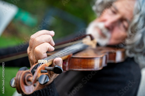 Elderly man in a masterful emotional violing performance photo
