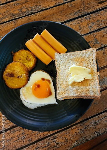 Heart shaped fried eggs with toast and sausages American style breakfast