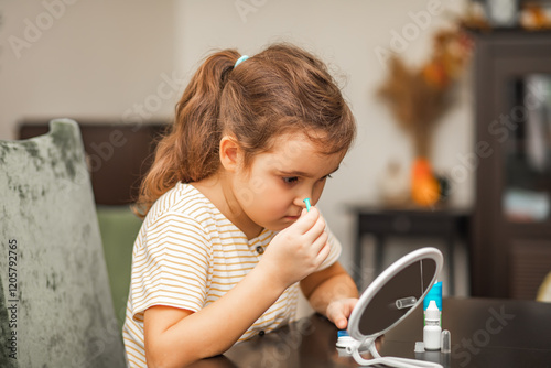Cute little girl inserting contact lenses into her eye. Vision correction and ophthalmology for children.
