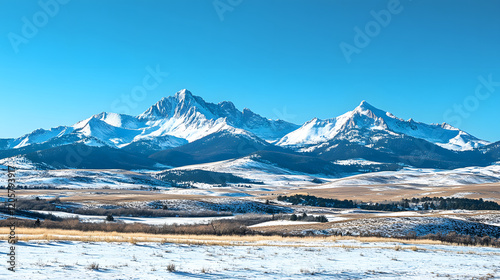 
A snowy mountain range with a clear blue sky in winter, snow covered mountains in winter