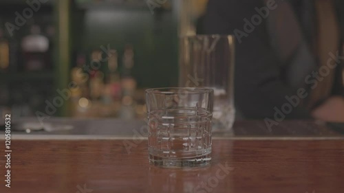 Close-up of a bartender preparing a cocktail with precision and skill, mixing ingredients in a modern bar setting