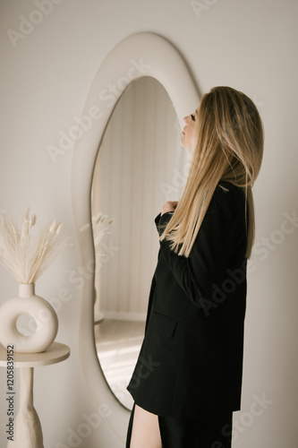 Obraz na płótnie Beautiful blonde woman posing in beautiful modern stylish beige interior on photo of large mirror w salonie
