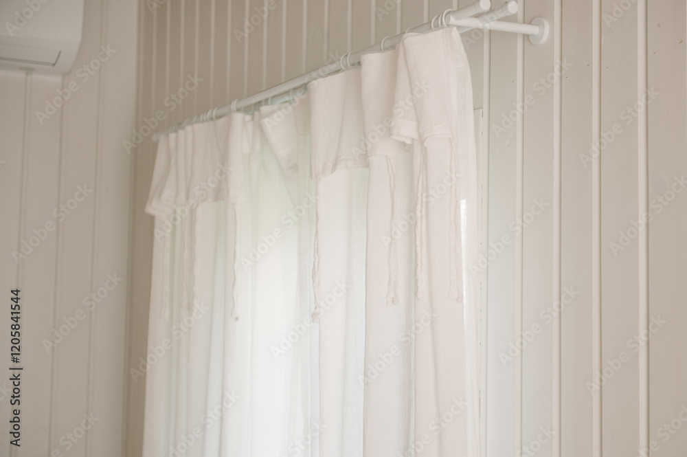 White curtains with ties in a stylish interior of a cozy home