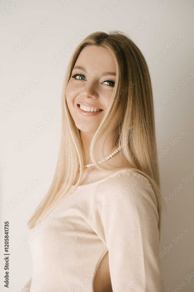 Portrait of smiling blonde woman with beautiful white smile in modern stylish beige interior Portrait of smiling blonde woman with beautiful white smile in modern stylish beige interior