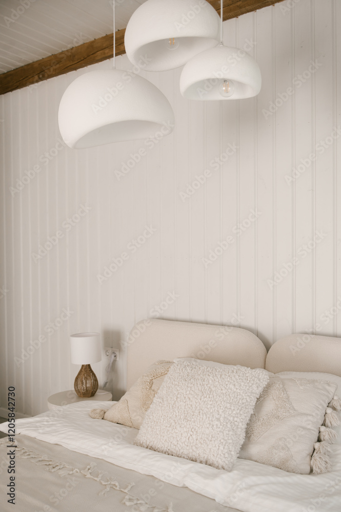 Beautiful light beige interior with soft white bed decorated with pillows in japandi and wawabi sabi style, cozy home concept