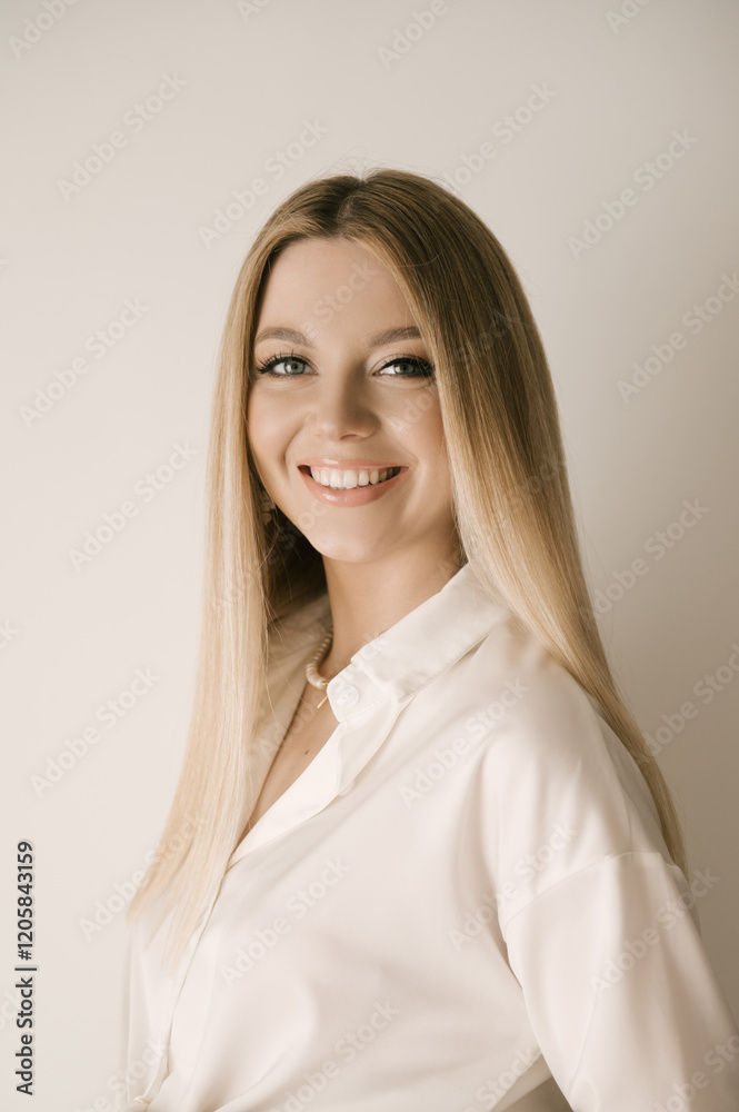 Portrait of smiling blonde woman with beautiful white smile in modern stylish beige interior