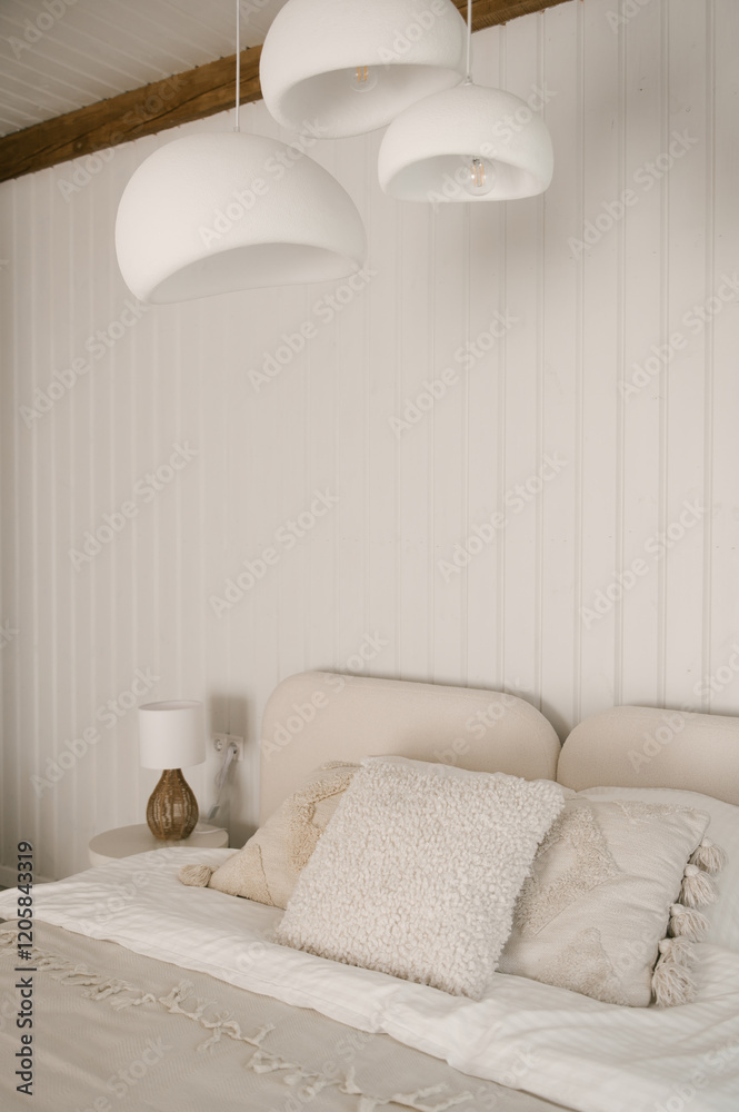 Beautiful light beige interior with soft white bed decorated with pillows in japandi and wawabi sabi style, cozy home concept