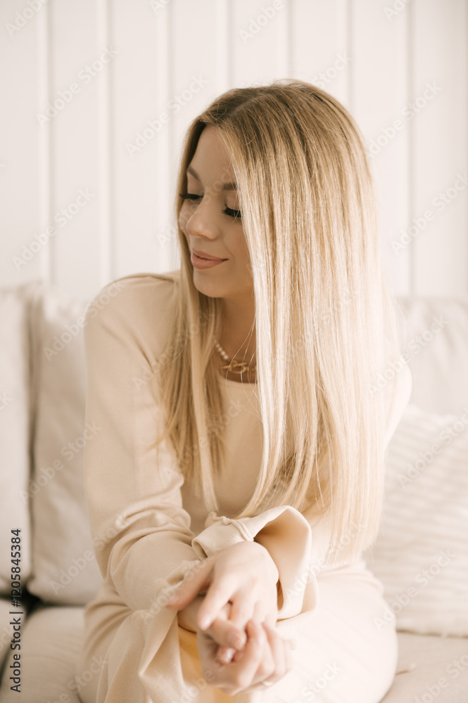 Beautiful blonde woman posing in a beautiful modern stylish beige interior
