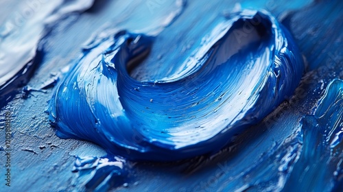 Close-up of thick, textured blue oil paint strokes on a palette. photo