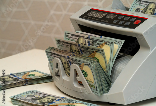 Money counting machine in action with stacks of cash nearby