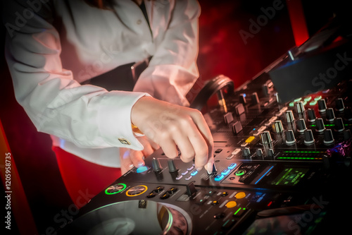 Close up DJ plays live set and mixing music on turntable console in the night club. Disc Jokey Hands on a sound mixer station at club party. DJ mixer controller panel for playing music and partying.