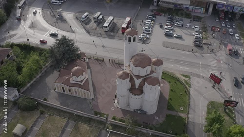Circular aerial shot of a church in the city of Skopje, showcasing its architecture and surrounding urban landscape