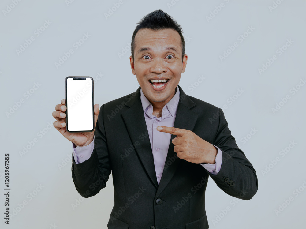 Mobile app advertisement. Handsome excited asian businessman showing white empty smartphone screen, posing on white studio background, smiling and pointing finger to mobile phone. Mobile app advertisement. Handsome excited asian businessman showing white empty smartphone screen, posing on white studio background, smiling and pointing finger to mobile phone.