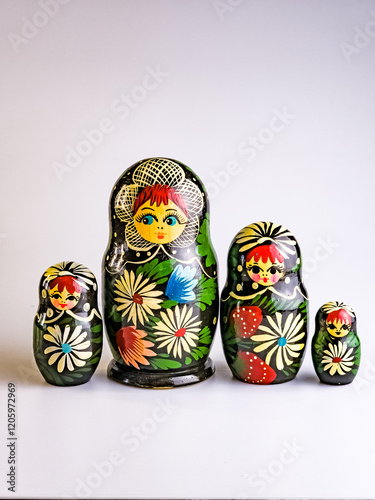 Four Matryoshka dolls of different sizes, Russian wooden doll on a white background. Painted with flowers. Vertical