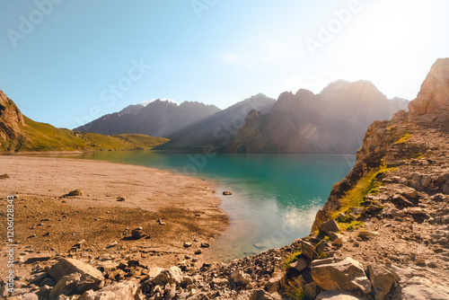 The front view of Tientang Hu lake, Xinjiang, China. There are many layers of mountains in the background. The sun was rising with yellow light reflected on the water. The idea for Trekking wallpaper