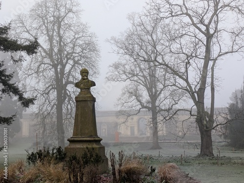 View of bust of Maxime Lalanne by Pierre Granet in 1895, Bordeaux (France) public garden with winter fog and capitol palace in the background