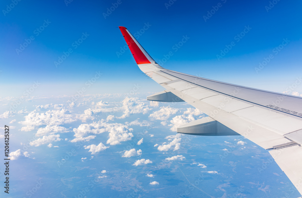 View from the airplane window at a beautiful cloudy sky and the airplane wing View from the airplane window at a beautiful cloudy sky and the airplane wing