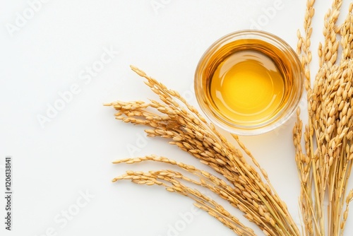 A flat lay image showcasing rice bran oil extract and unprocessed rice, isolated on a white surface, from a top view photo