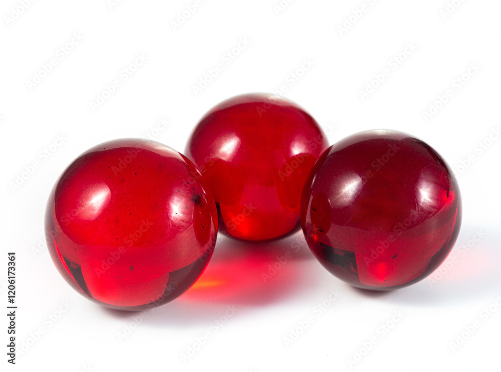 Three red glass balls are sitting on a white background Three red glass balls are sitting on a white background