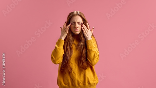 Young red-hair woman keeping her eyes closed, suffering from seasonal allergy and allergy on products on pink studio background. Concept of illness, medicine, treatment, health care photo