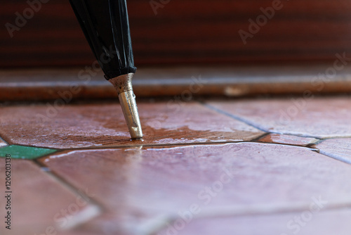 Wet umbrella on tiled floor
