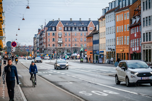 COPENHAGEN, DENMARK - December 24 2024: A busy pedestrian street in Copenhagen under a gray winter sky, lined with historic buildings adorned with Christmas lights and decorations.