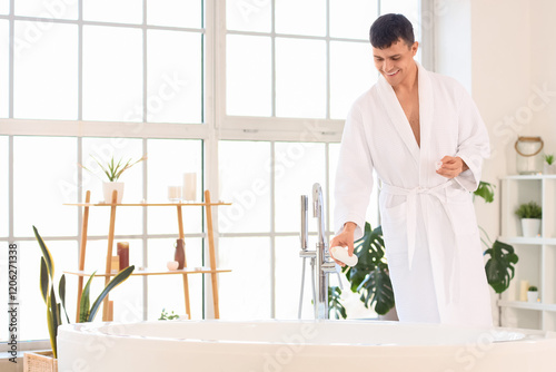 Young man pouring foam into...