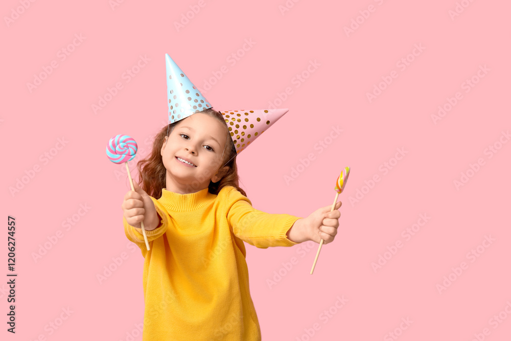 Cute little girl in holiday caps showing lollipops on pink background Cute little girl in holiday caps showing lollipops on pink background
