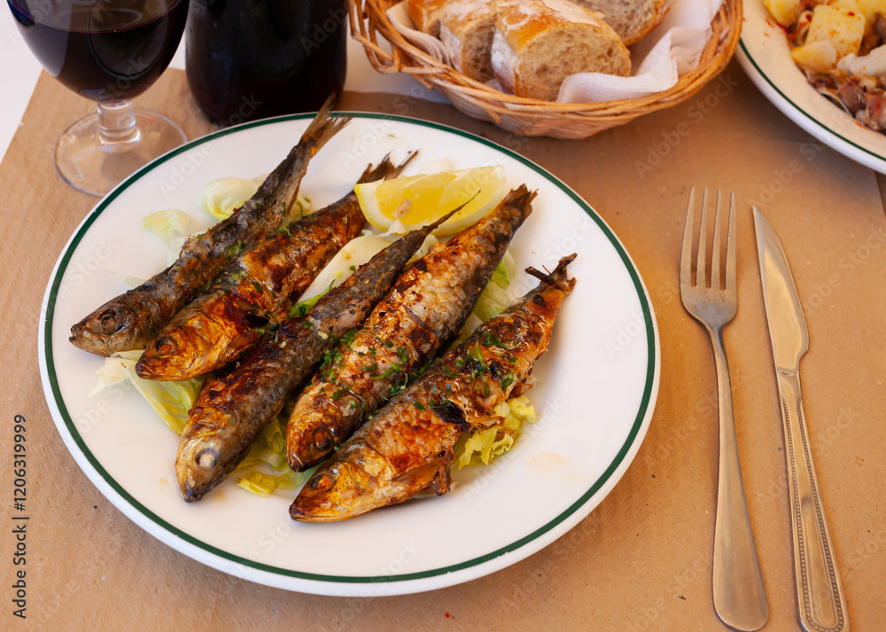 Portion of fried sardines served with lemon, typical dish of Spain Portion of fried sardines served with lemon, typical dish of Spain