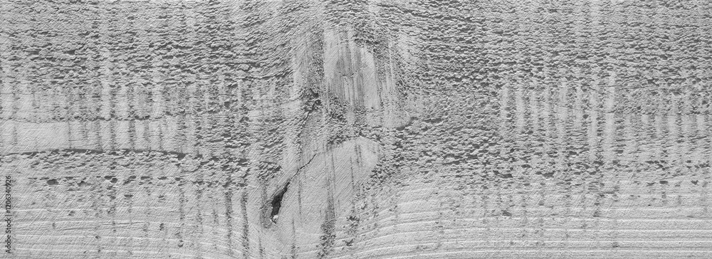 Obraz premium A wooden surface with a grainy texture. The wood appears to be aged and worn, giving it a rustic and natural feel. The grain of the wood is visible