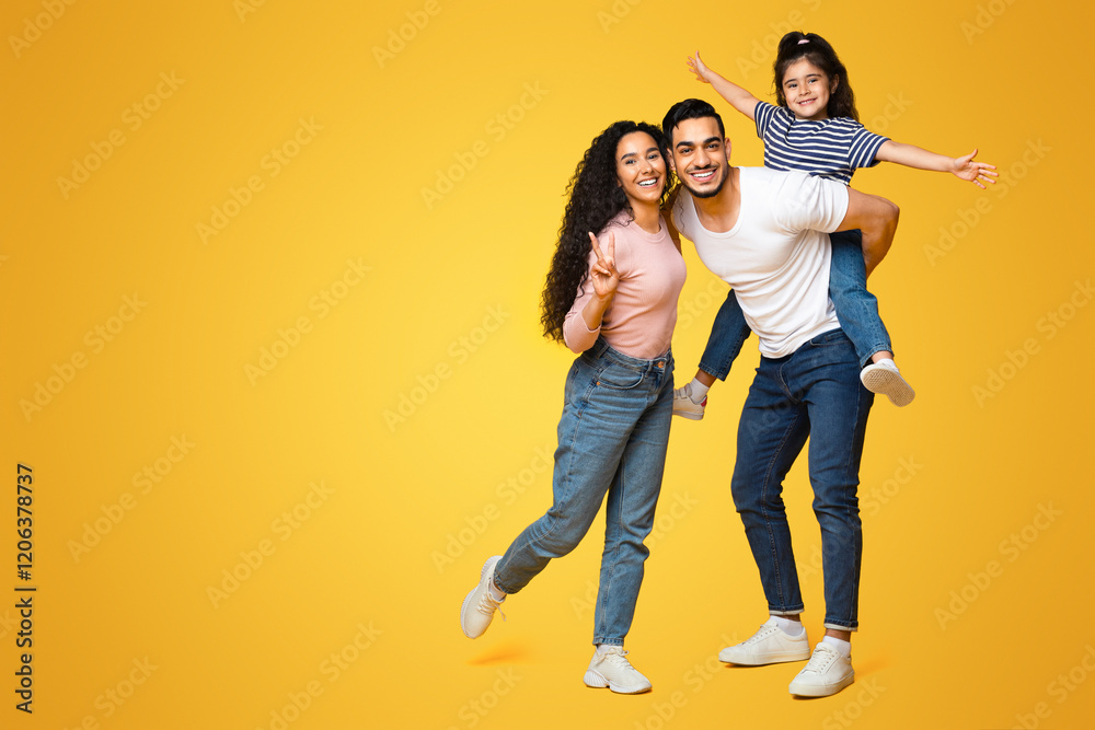 Cheerful Middle Eastern Family Of Three Having Fun Together Over Yellow Background, Happy Young Arab Parents And Their Little Daughter Laughing And Smiling At Camera, Full Length Shot, Copy Space Cheerful Middle Eastern Family Of Three Having Fun Together Over Yellow Background, Happy Young Arab Parents And Their Little Daughter Laughing And Smiling At Camera, Full Length Shot, Copy Space