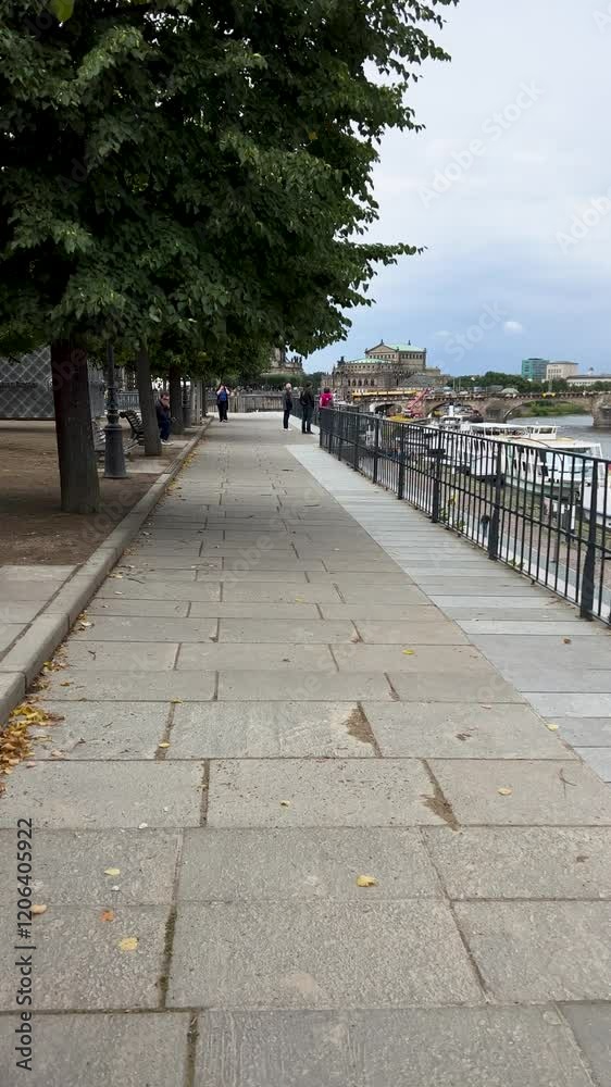 Enjoy a Scenic Riverside Walk Featuring Lush Green Trees and Beautiful Historic Architecture Enjoy a Scenic Riverside Walk Featuring Lush Green Trees and Beautiful Historic Architecture