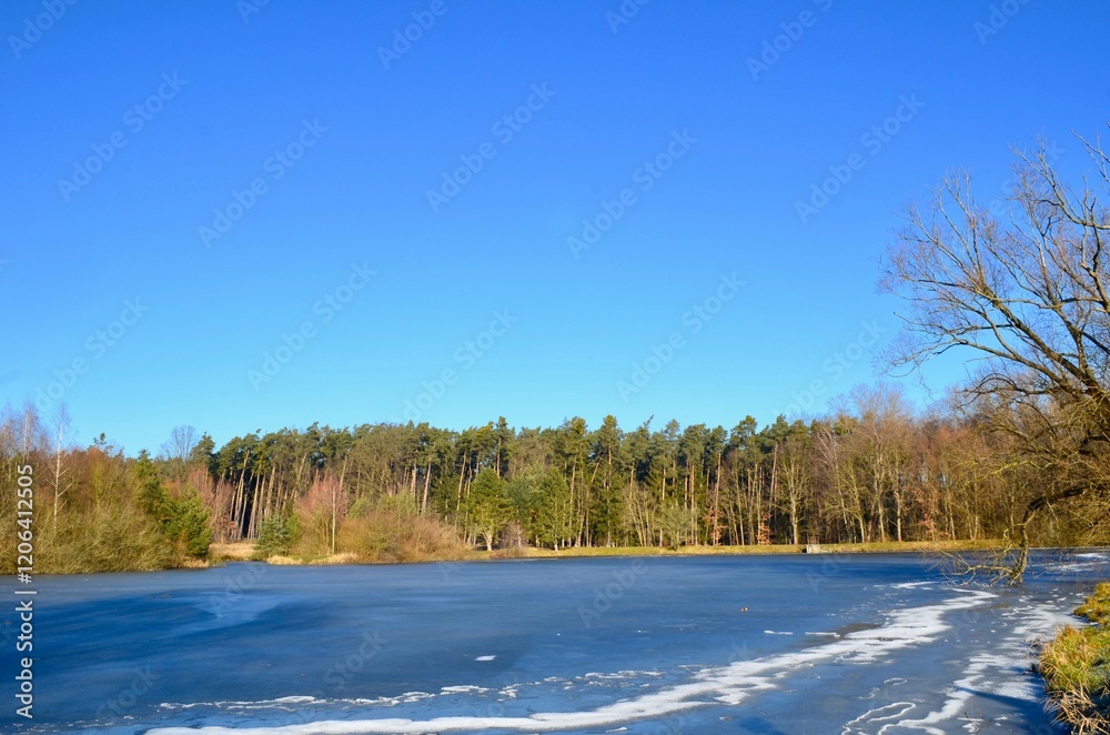 landscape of a winter frozen lake, the surface of the lake is covered with ice, blue sky, sunny day landscape of a winter frozen lake, the surface of the lake is covered with ice, blue sky, sunny day