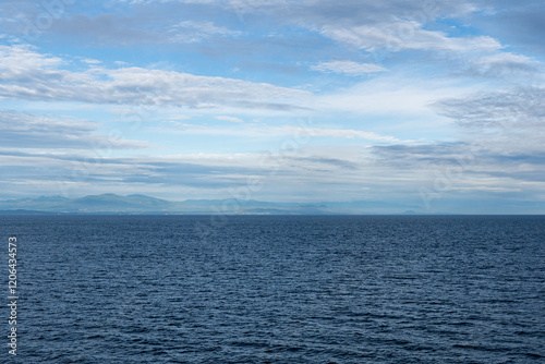clouds over Strait of Georgia blue sky water landscape mountains on the horizon British Columbia Canada