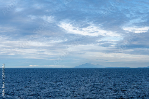 clouds over Strait of Georgia blue sky water landscape mountains on the horizon British Columbia Canada