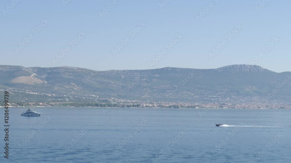 A scenic coastal view with boats and majestic mountains, ideal for travelers and nature lovers A scenic coastal view with boats and majestic mountains, ideal for travelers and nature lovers