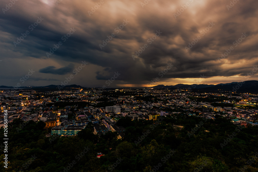 Fototapeta premium Nature background from Phuket city viewpoint, Khao Rang viewpoint, with black rain clouds covering the evening, changing seasons according to the time of the rainy season.