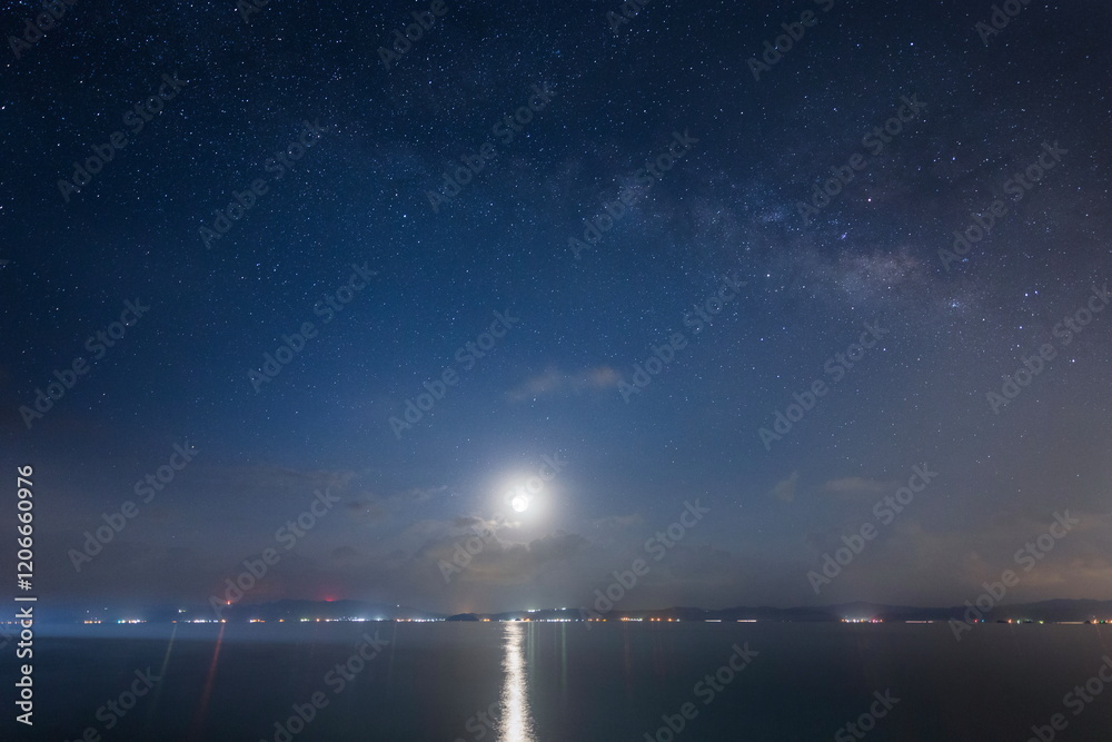 沖縄の海岸から望む月あかりと水面の光の道と星