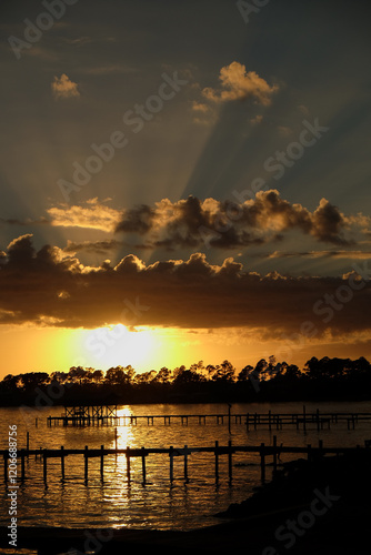 Fototapeta Naklejka Na Ścianę i Meble -  streaming light sunset on the bay with docks in silhouette