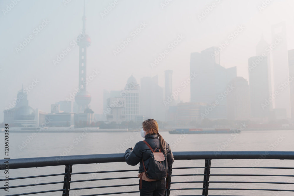young Asian woman wearing respiratory mask protect and filter pm or particulate matter against bad Air Pollution in Shanghai City, China. Air Quality Index, AQI, Unhealthy, healthcare concept young Asian woman wearing respiratory mask protect and filter pm or particulate matter against bad Air Pollution in Shanghai City, China. Air Quality Index, AQI, Unhealthy, healthcare concept