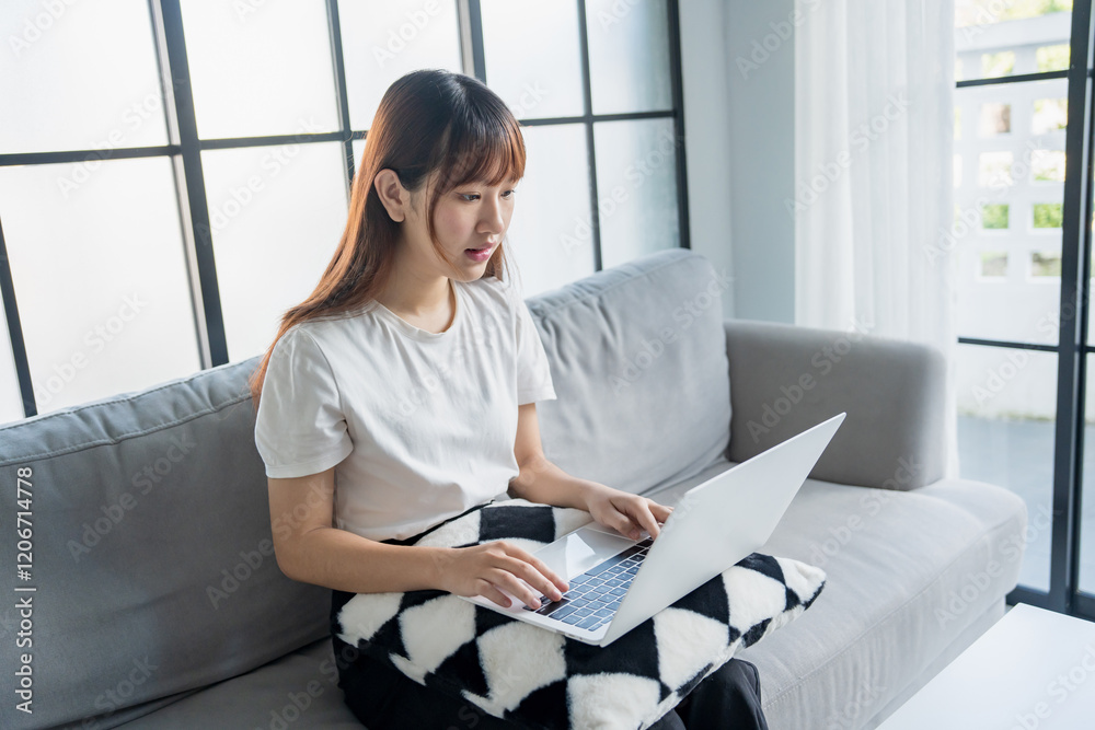 Obraz premium Asian woman watching entertainment video streaming by laptop