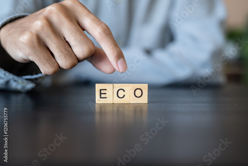 ECO concept. Business man hand holding wooden cube words ECO on a wood block
