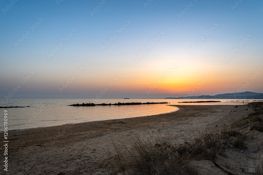 Serene Sandy Beach with a Peaceful Sunset over the Sea